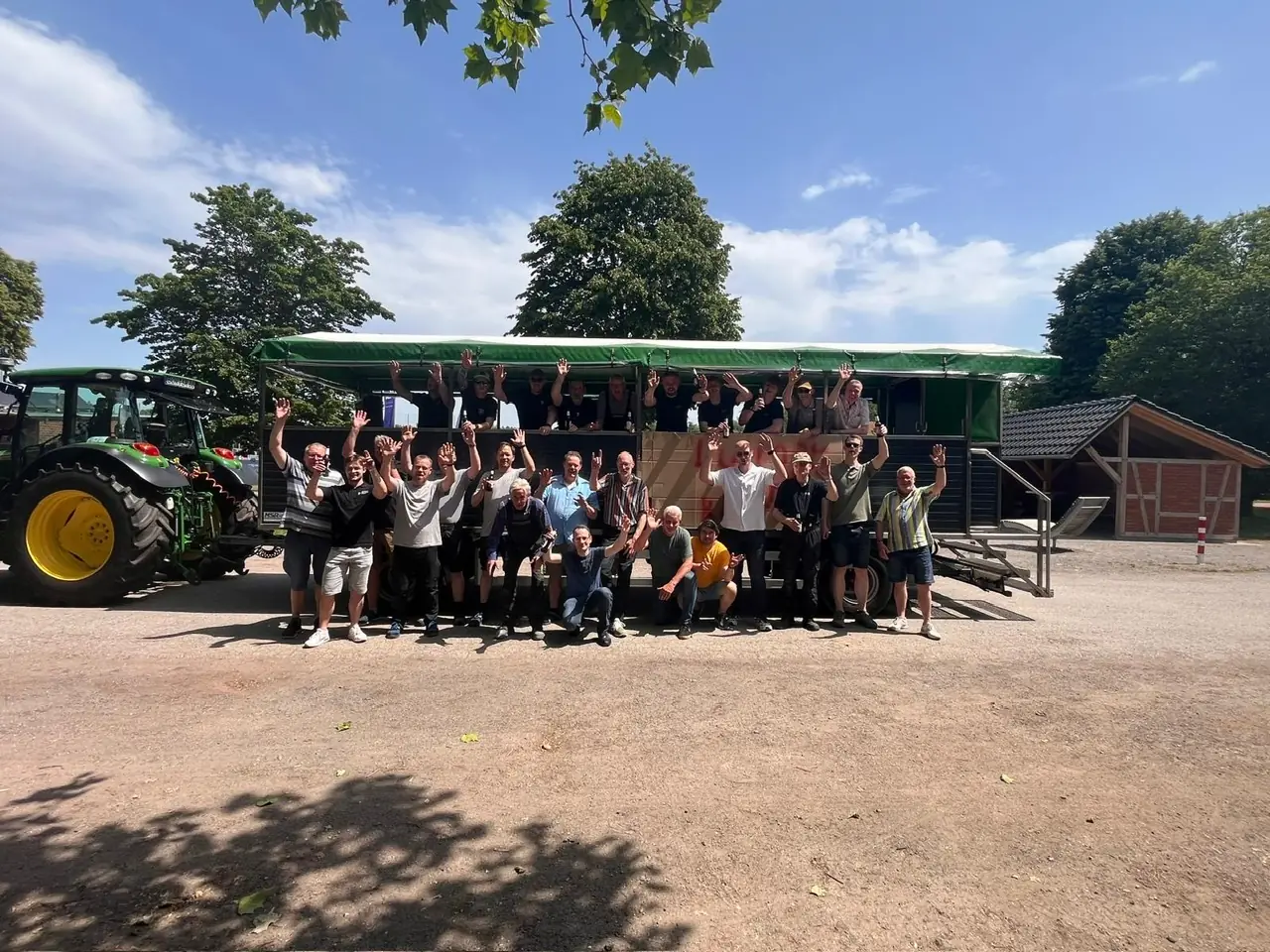 Feiernde Gruppe vor dem neuen 34-Personen-Planwagen